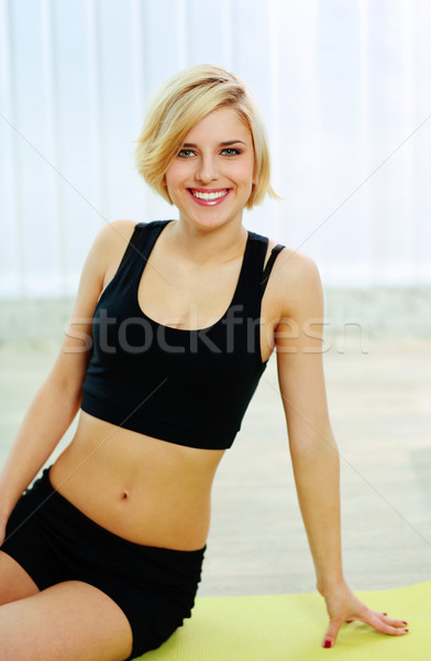 Portrait of a young fit woman sitting on the yoga mat Stock photo © deandrobot