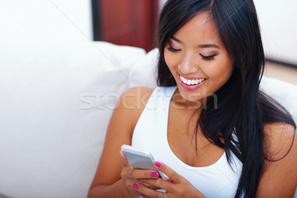 Gyönyörű fiatal ázsiai nő sms üzenetküldés okostelefon Stock fotó © deandrobot