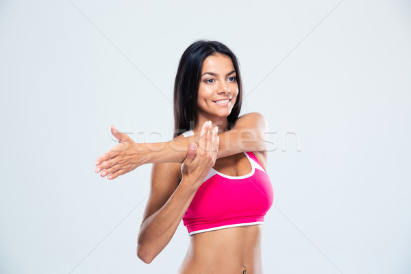 Smiling sports woman stretching hands Stock photo © deandrobot
