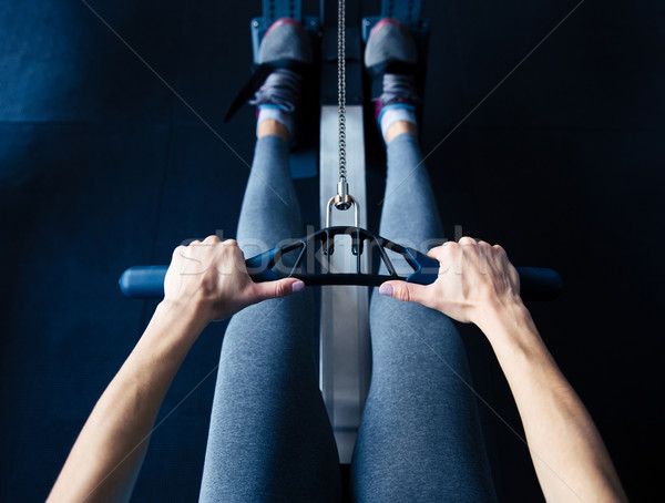 Stock photo: Closeup image of a woman working out on simulator at gym