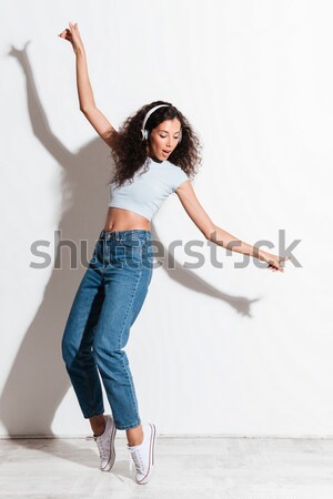 Full length portrait of smiling sports woman jumping Stock photo © deandrobot