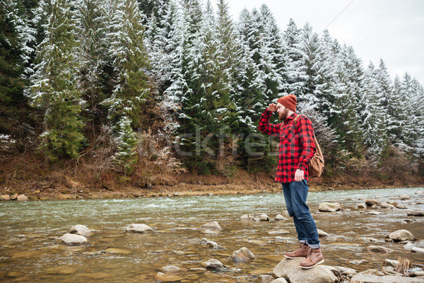 Male hiker standing on the stone in river Stock photo © deandrobot