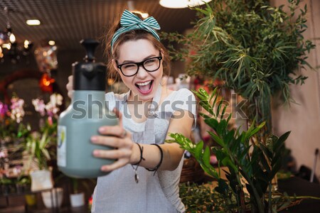 [[stock_photo]]: Femme · fleuriste · fleurs · pointant · drôle