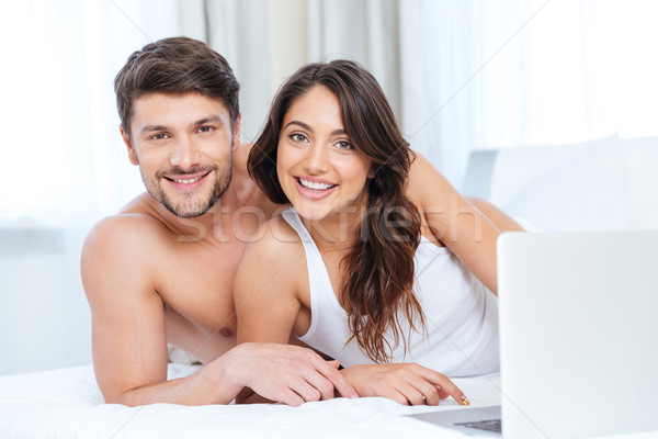Foto stock: Sorridente · belo · casal · usando · laptop · olhando · câmera