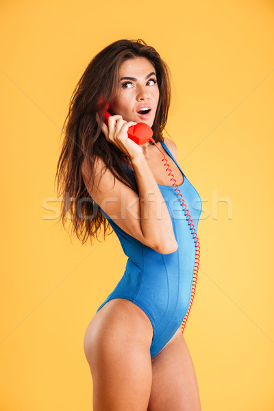 Meglepett fürtös nő kék fürdőruha beszél Stock fotó © deandrobot