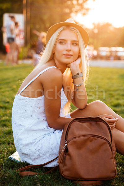 Beautiful blonde young woman with backpack sitting in the park Stock photo © deandrobot