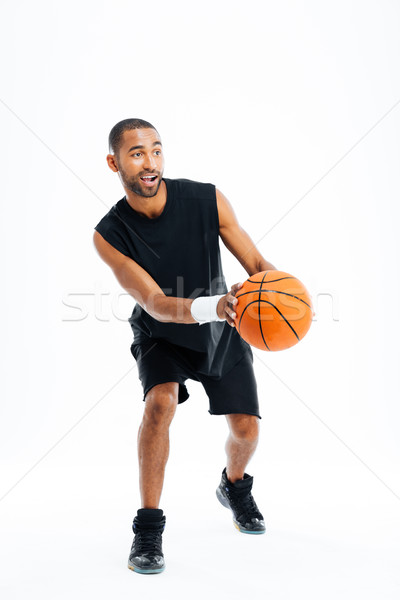 Full length portrait of a smiling sports man playing basketball Stock photo © deandrobot