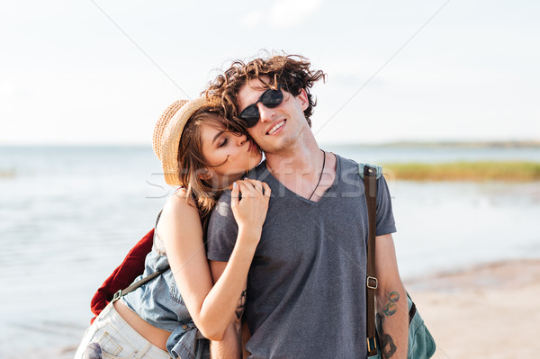 Couple with backpacks standing and kissing on the beach Stock photo © deandrobot