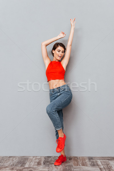 Full length portrait iof a woman standing with raised hands Stock photo © deandrobot