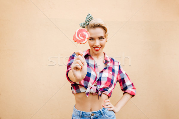 Mosolyog bájos pinup lány áll mutat Stock fotó © deandrobot