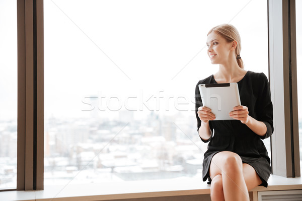 Woman worker in office near window holding tablet computer Stock photo © deandrobot
