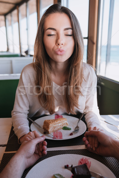 Verical image of pretty woman on date sands air kiss Stock photo © deandrobot