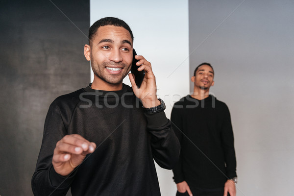 Afrikai fiatalember vár barát beszél mobiltelefon Stock fotó © deandrobot