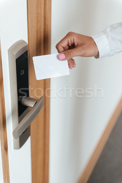 Woman hand inserting key card in electronic lock Stock photo © deandrobot