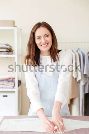 Seamstress sitting near sewing machine and talking Stock photo © deandrobot