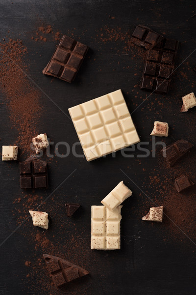Top view of white and dark crashed chocolate bar tiles Stock photo © deandrobot