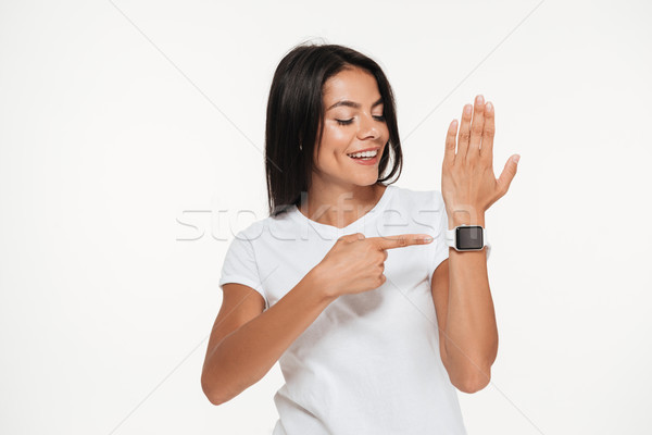 Portrait of a happy woman pointing finger at smart watch Stock photo © deandrobot