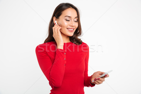 Stock photo: Portrait of a pleased happy asian woman in earphones