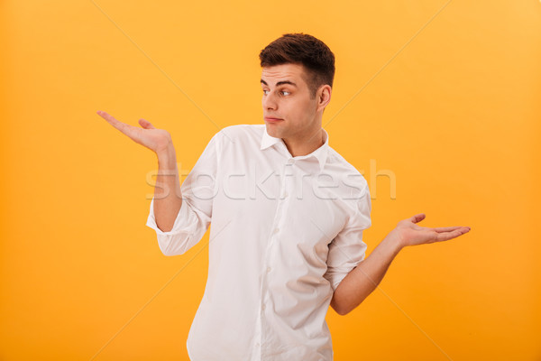 Confused man in white shirt shrugs his shoulder Stock photo © deandrobot