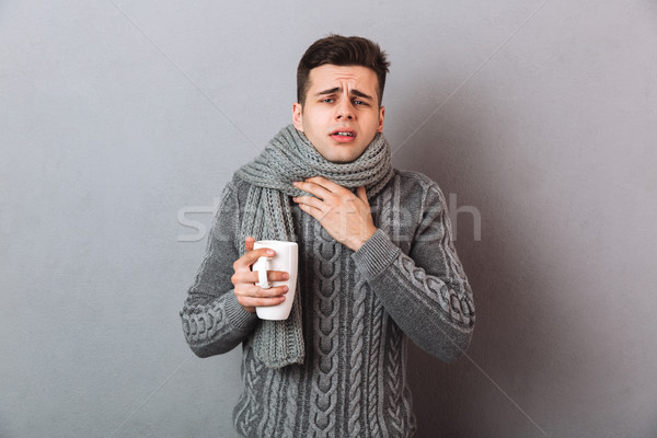 Doente homem suéter cachecol garganta inflamada Foto stock © deandrobot