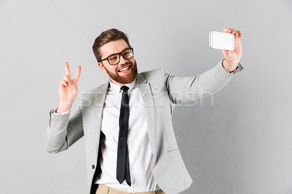 Portrait of a cheerful businessman dressed in suit Stock photo © deandrobot