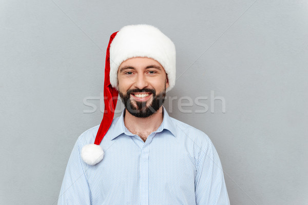 Smiling Bearded man in business clothes and christmas hat Stock photo © deandrobot
