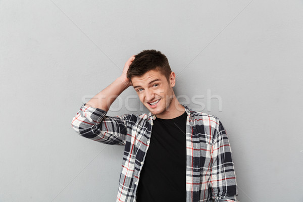 Portret onzeker jonge man handen hoofd grijs Stockfoto © deandrobot