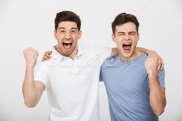Photo of two happy mates 30s wearing casual t-shirt and jeans hu Stock photo © deandrobot