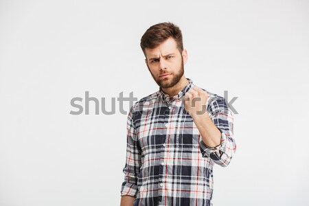 Portrait of an angry young man threatening with a fist Stock photo © deandrobot