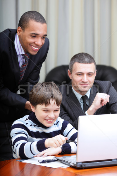 Kid boy explains multi ethnic business team how to work Stock photo © deandrobot