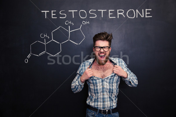Stock photo: Aggressive man in glasses screaming and tearing off his shirt 