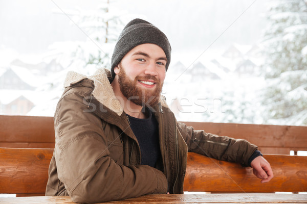 Cheerful man sitting outdoors in winter Stock photo © deandrobot