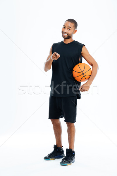 Sportsman holding basket ball and pointing finger at camera Stock photo © deandrobot