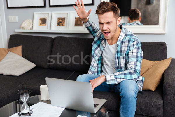 Angry bristle man using laptop computer Stock photo © deandrobot