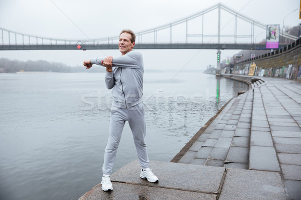 Full length runner warming up near the river Stock photo © deandrobot