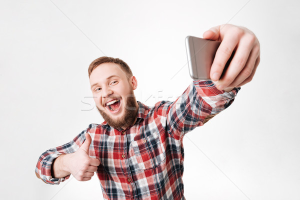 Happy Bearded man in shirt making selfie Stock photo © deandrobot