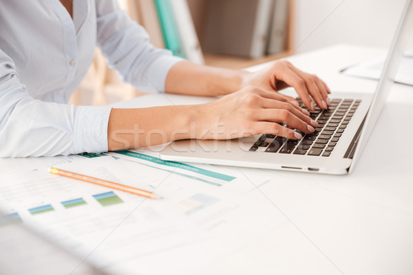 Cropped photo of businesswoman using laptop. Stock photo © deandrobot