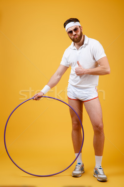 Handsome sportsman standing with gymnastic hoop make thumbs up gesture Stock photo © deandrobot