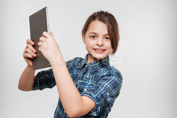 Happy young girl using tablet computer Stock photo © deandrobot