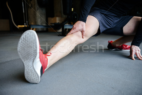 Cropped image of Muscular man warming up Stock photo © deandrobot