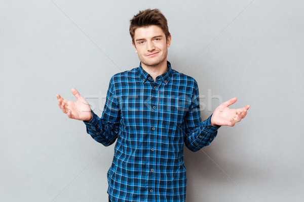 Upset man don't know what to do and gesturing hands Stock photo © deandrobot