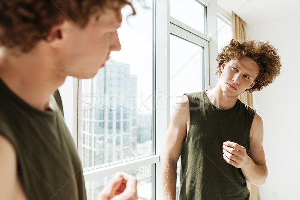 Handsome man looking at mirror Stock photo © deandrobot