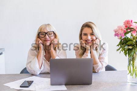 Cheerful young lady sitting at home with her grandmother Stock photo © deandrobot