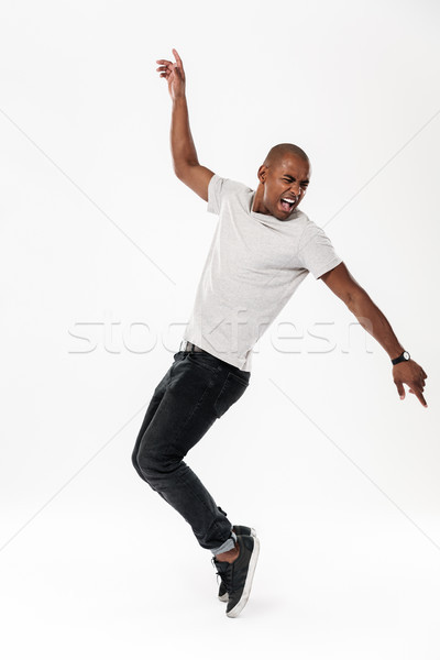 Emotional screaming young african man dancing isolated Stock photo © deandrobot