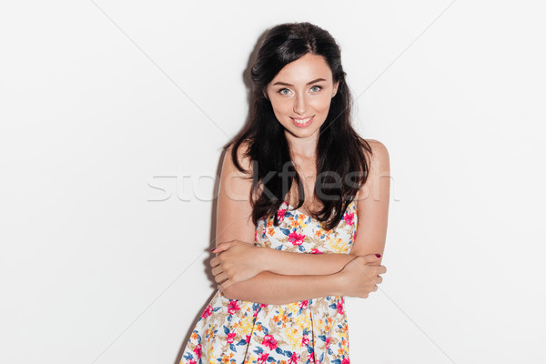 Smiling brunette woman posing in studio with crossed arms Stock photo © deandrobot