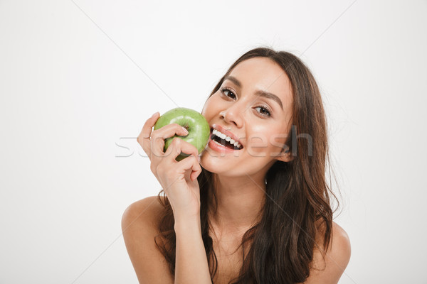 Image of Happy woman eating apple and looking at camera Stock photo © deandrobot