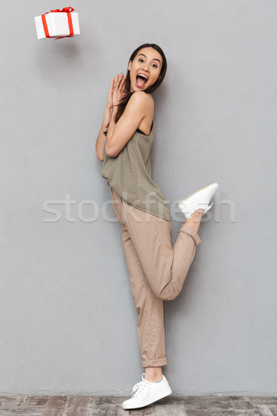 Full length portrait of an excited young asian woman Stock photo © deandrobot