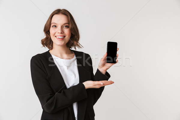 Smiling young woman standing isolated showing display Stock photo © deandrobot