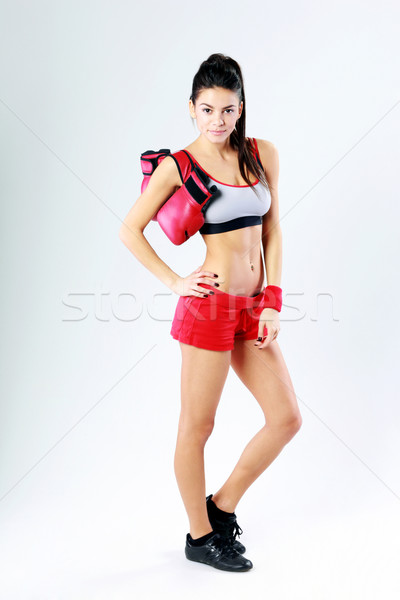 Young happy sport woman with boxing gloves on gray background Stock photo © deandrobot