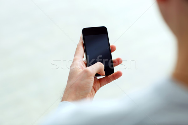 Bild Mann halten Smartphone schauen Stock foto © deandrobot